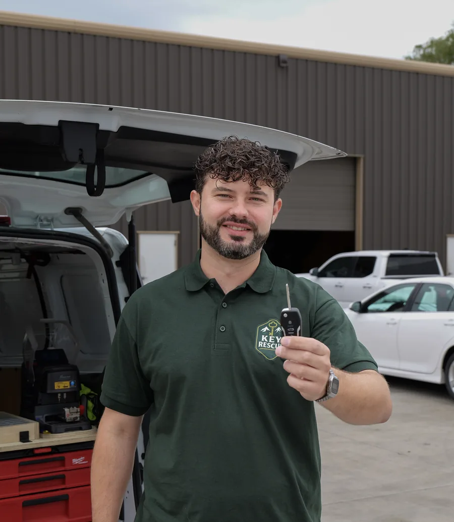 Key Rescue Washington owner holding a freshly cut car key beside the service van in Spokane, WA