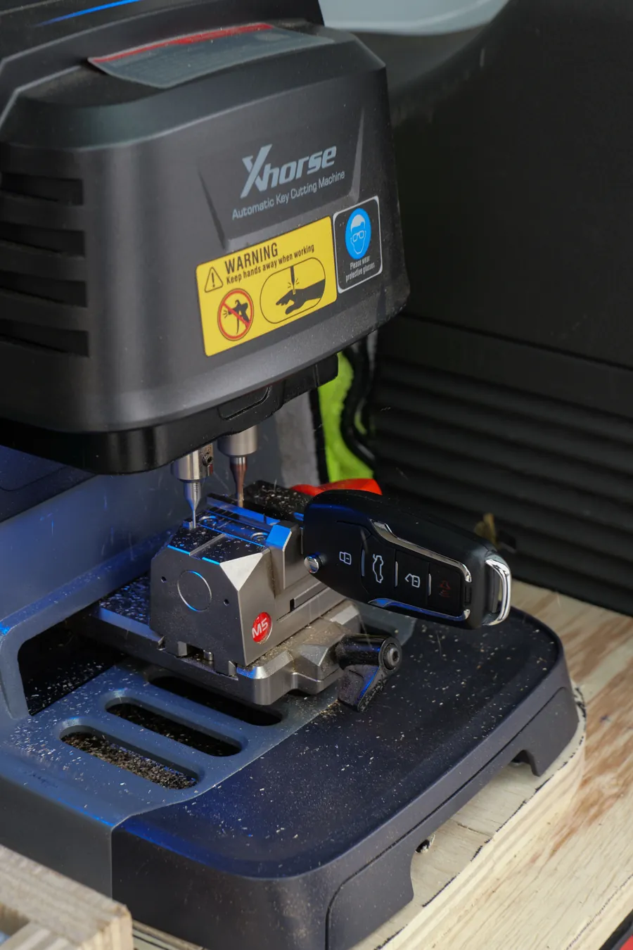Laser-cut car key fob clamped in the Xhorse cutting machine in the van, Spokane, WA